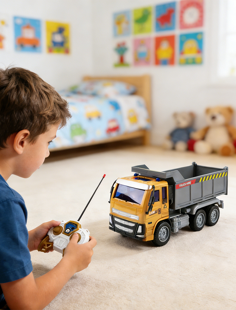 A little boy sits in the room holding a remote control, playing with a Remote Control Engineering Truck